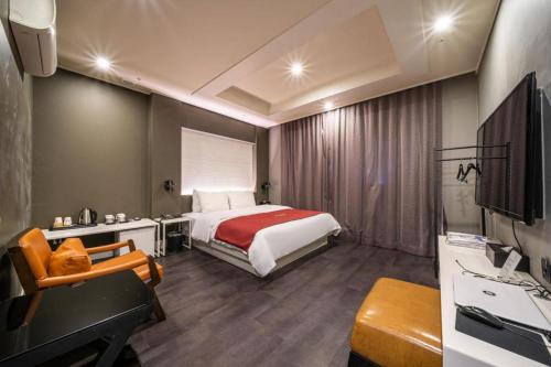 a bedroom with a bed and a desk and a sink at Hotel Floce in Bucheon