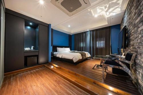 a bedroom with a bed and a brick wall at Hotel Floce in Bucheon