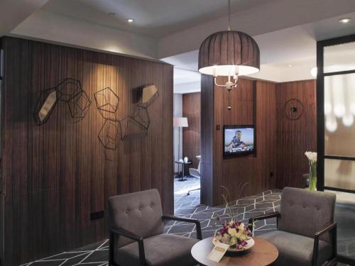 a living room with two chairs and a table at Chongqing The Lotus Hotel in Chongqing