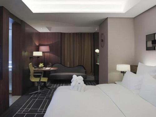 a hotel room with a bed and a desk at Chongqing The Lotus Hotel in Chongqing