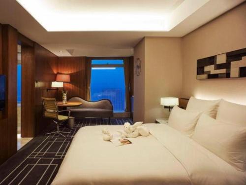 a hotel room with a large bed and a desk at Chongqing The Lotus Hotel in Chongqing