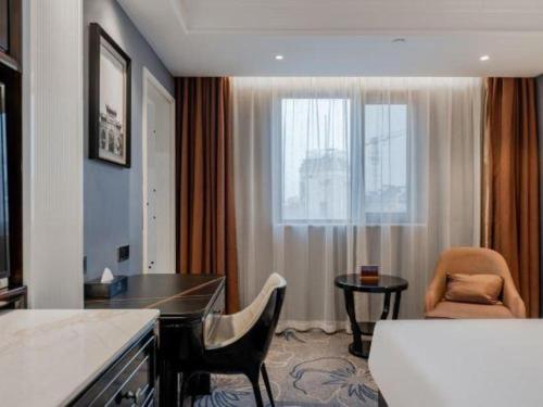 a hotel room with a desk and a window at Jinjiang Metropolo Hotel Nanjing Confucius Temple Branch in Nanjing