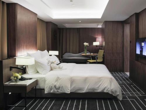 a hotel room with a large bed and a television at Chongqing The Lotus Hotel in Chongqing