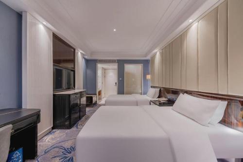 a hotel room with two beds and a television at Jinjiang Metropolo Hotel Nanjing Confucius Temple Branch in Nanjing