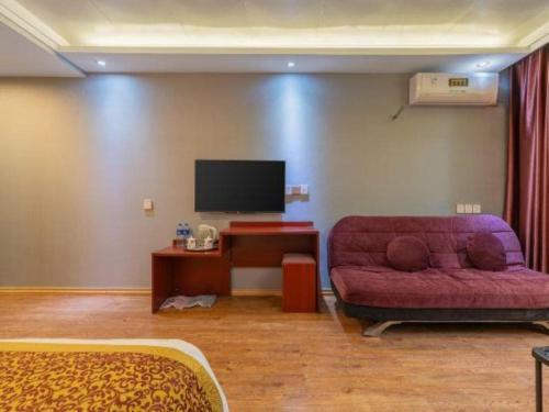 a living room with a couch and a flat screen tv at Super 8 Hotel Shiyan Beijing Middle Road in Shiyan