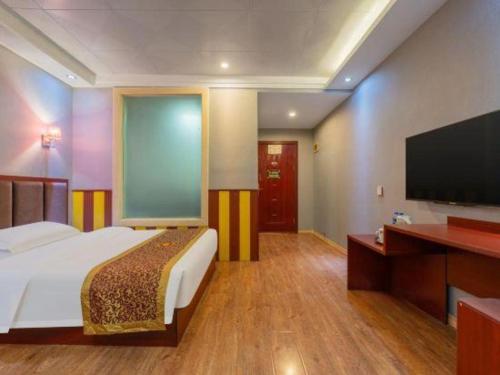 a bedroom with a bed and a flat screen tv at Super 8 Hotel Shiyan Beijing Middle Road in Shiyan
