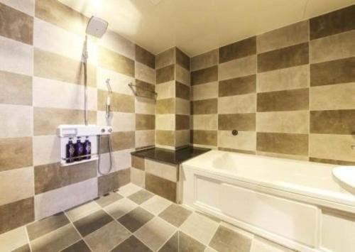 a bathroom with a shower and a tub and a sink at H Hotel in Ulsan