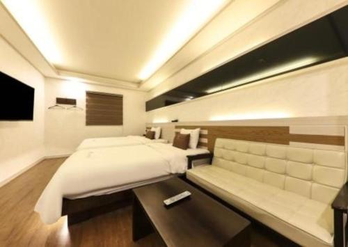 a bedroom with a large bed and a table at H Hotel in Ulsan