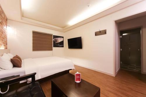 a hotel room with a bed and a table in a room at H Hotel in Ulsan