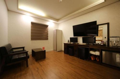 a living room with a large flat screen tv at H Hotel in Ulsan