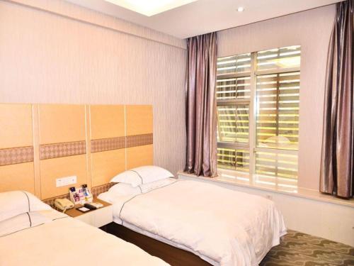 a bedroom with two beds and a window at Super 8 Hotel Yiwu Binwang in Yiwu