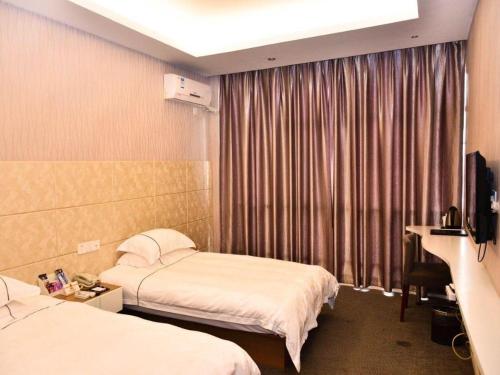 a hotel room with two beds and a television at Super 8 Hotel Yiwu Binwang in Yiwu