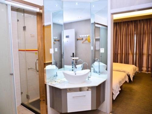 a bathroom with a sink and a shower and a bed at Super 8 Hotel Yiwu Binwang in Yiwu
