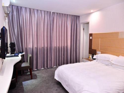 a hotel room with a bed and a desk and a window at Super 8 Hotel Yiwu Binwang in Yiwu