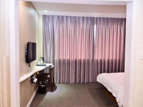 a hotel room with a bed and a desk and a television at Super 8 Hotel Yiwu Binwang in Yiwu
