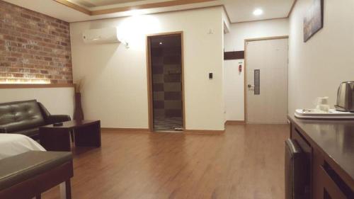 a living room with a couch and a door to a room at H Hotel in Ulsan