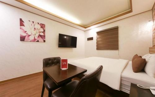 a hotel room with a table and a bed and a desk at H Hotel in Ulsan