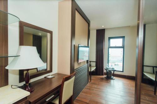 a room with a desk with a lamp and a mirror at Hung Long Hotel in Bắc Ninh