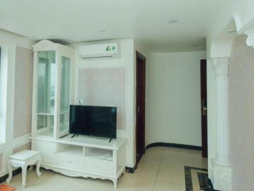 a living room with a tv on a white wall at Hung Long Hotel in Bắc Ninh