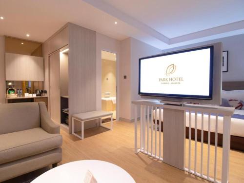 a living room with a television on a table at PARK HOTEL Cawang Jakarta in Jakarta