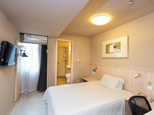 a hotel room with a bed and a television at Jinjiang Inn Wuhu Fangte Tech Museum Metro Station in Wuhu