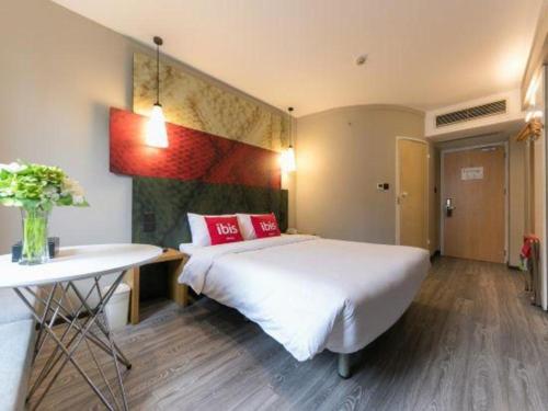 a bedroom with a bed and a desk and a table at Ibis Ya An Langqiao in Ya'an