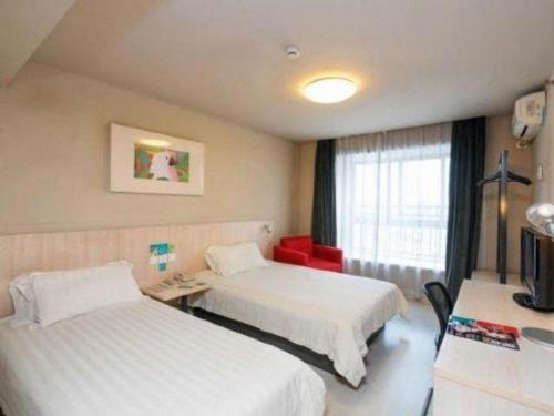 a hotel room with two beds and a window at Jinjiang Inn Wuhu Fangte Tech Museum Metro Station in Wuhu