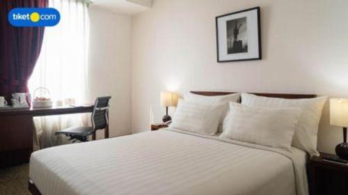 a hotel room with a bed and a window at PARK HOTEL Cawang Jakarta in Jakarta