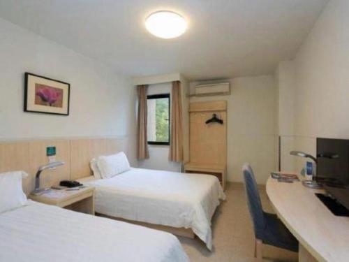 a hotel room with two beds and a desk at Jinjiang Inn Wuhu High-Speed Railway Station West Square in Wuhu