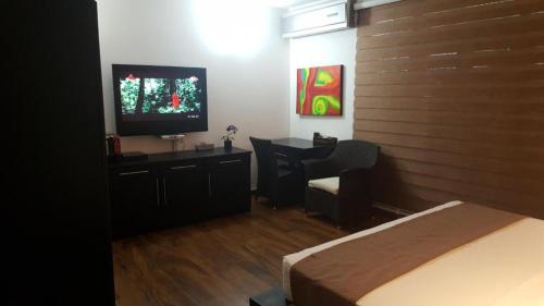 a bedroom with a bed and a desk and a television at D Villas in Colombo