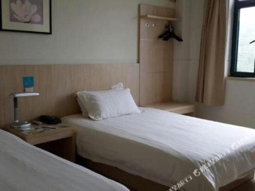 a small bedroom with a bed and a window at Jinjiang Inn Wuhu High-Speed Railway Station West Square in Wuhu