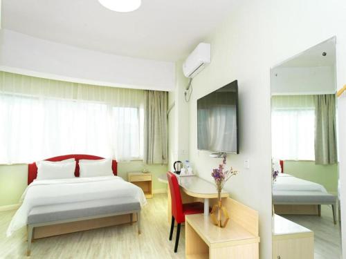 une chambre d'hôtel avec un lit, une table et un bureau dans l'établissement Super 8 Hotel Chengde Imperial Summer Resort, à Chengde