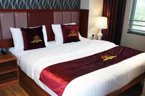 a bedroom with a bed with red and gold pillows at Metro Winner Hotel in Hong Kong