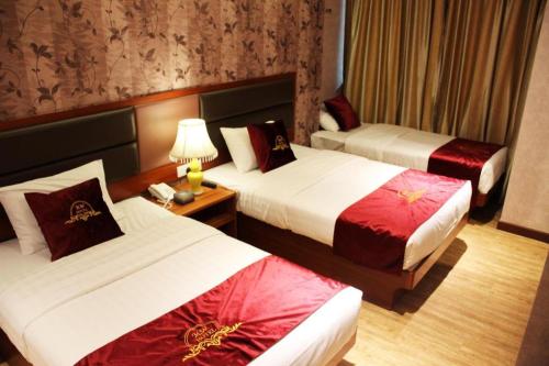 a hotel room with two beds and a table at Metro Winner Hotel in Hong Kong