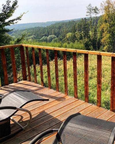 a wooden deck with a view of a field at KarpatyGlamp in Rudimov