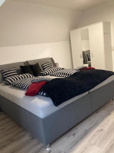 a bedroom with a large bed with black and white pillows at Ostfrieslandsuite in Aurich