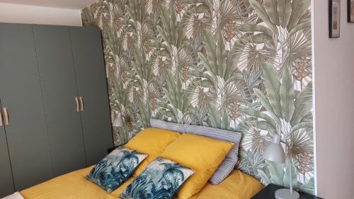 une chambre avec un lit avec un papier peint tropical dans l'établissement Ty Kosy 2 ch vue imprenable Ria Etel, à Étel