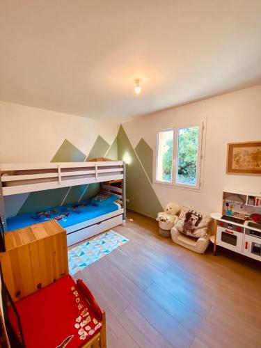 Cette chambre pour enfants comprend des lits superposés et une chaise. dans l'établissement Villa 9 people maximum, à Bagnols-en-Forêt