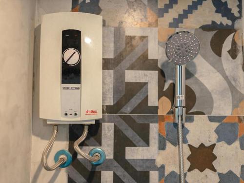 a hair dryer on a wall next to a shower at B2 Krabi Premier Hotel in Ao Nang Beach
