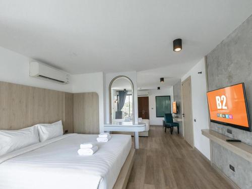 a hotel room with a white bed and a television at B2 Krabi Premier Hotel in Ao Nang Beach