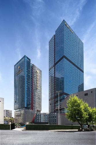 two tall skyscrapers in a city with a tree at Lyhn International Hotel Chengdu Taikoo Li in Chengdu