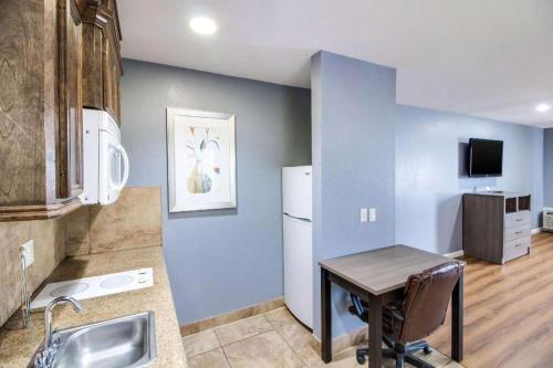 a kitchen with a small table and a refrigerator at Rodeway Inn & Suites Port Arthur - Groves in Port Arthur