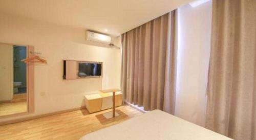 a room with a bed and a window and a television at 7 Days Inn·Ulanqab Tsining railway station in Ulanqab