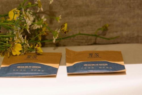 two certificates on a table with a vase with flowers at Atour Hotel Weihai Shidao in Dongshan