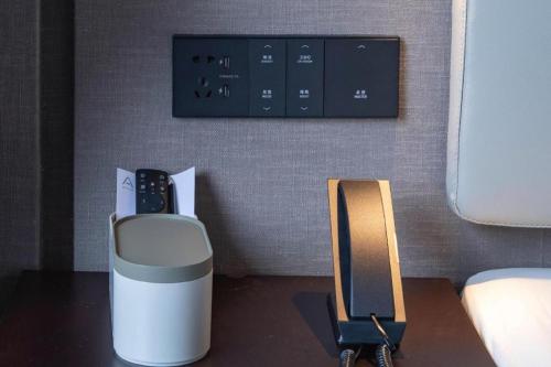 a room with a phone on a table next to a bed at Atour Hotel Weihai Shidao in Dongshan