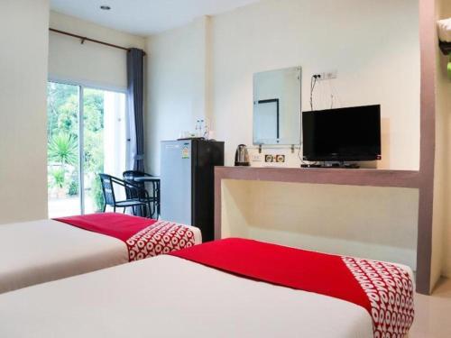 2 lits dans une chambre avec une télévision et une chambre dans l'établissement OYO 902 Life and Love Resort, à Ban Khlong Haeng