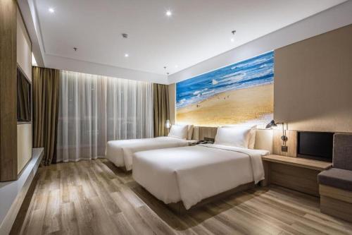 a hotel room with two beds and a television at Atour Hotel Weihai Shidao in Dongshan