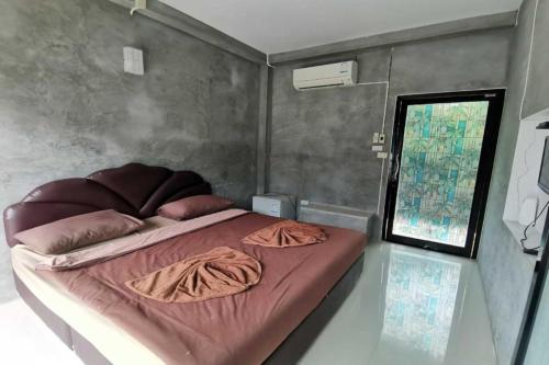 a bedroom with a large bed with pink sheets at OYO 1167 Ban Pa Rim Khuean in Nakhon Nayok