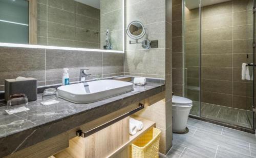 a bathroom with a sink and a toilet at Atour Hotel Weihai Shidao in Dongshan