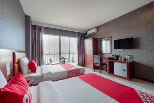 une chambre d'hôtel avec deux lits et une télévision dans l'établissement OYO 1130 CK Resort Pattaya, à Nong Prue